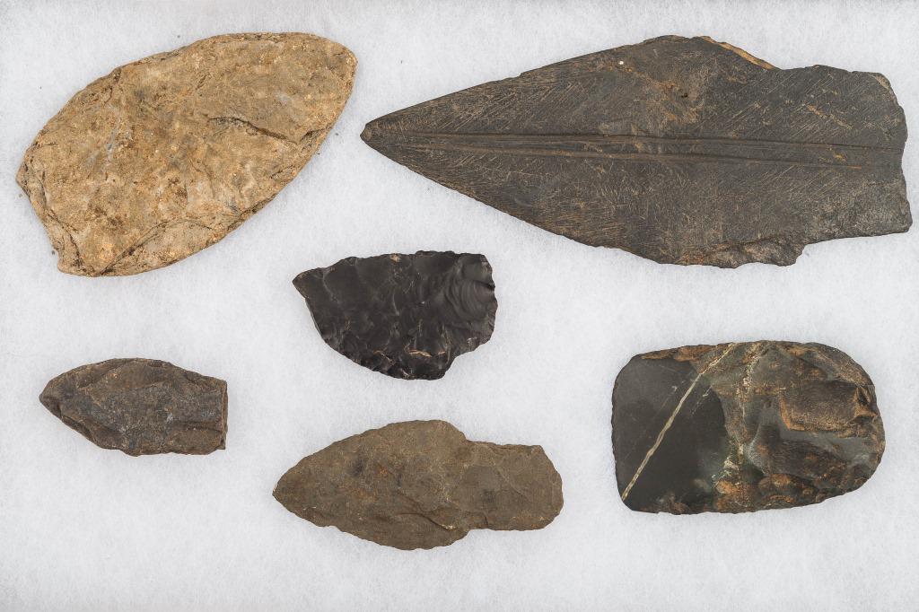 Inuit Knife Blades (6): The largest is slate approx 6.5", the next largest is rhyolite approx 4.5", the rectangular shaped items is jade and used as an adze or chisel, and the others are chert or some form of rhyolite. Inuit
