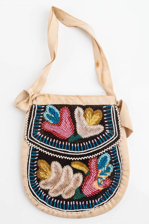 19th C/Early 20th C Iroquois Beaded Purse: This antique Native American beaded bag / purse has multi-color bead floral decoration on both sides on brown cloth backing, flaps both side, center opening, applied to natural woven material, and app
