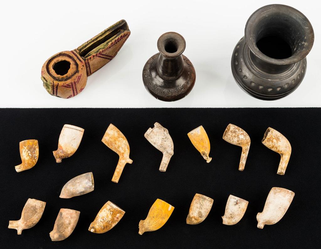 Pipes and Stone and Other Pottery: Two pieces of pottery, the larger is signed Oaxaca with other markings and the other is not marked (possibly Middle Eastern). There are approx 16 used excavated tavern pipes. The early stone oil lamp 