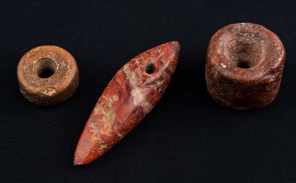 Neolithic Bura Culture Beads & Pendant: Neolithic Bura culture reddish jasper beads and pendant from Niger, artifacts approx 1200 BC, pendant approx 3.5"L, largest bead approx 1.25"L x 1.5" diam, small bead 1.25" diam.