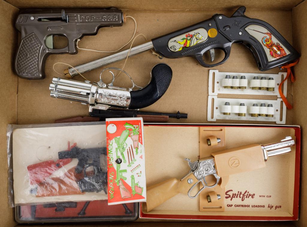 Vintage Toy Pistols & Secret Agent Kit: 3 Tin pop guns, 5 toy pistols and rifles (1 metal, 4 plastic) including pepperbox, secret agent kit and Nichols brand Spitfire, and 2 ammo belts.