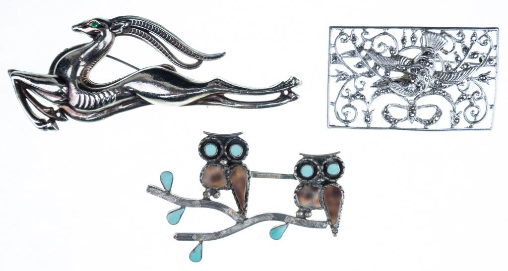 Sterling Paul Lucario Jr Pin, Figural Brooches: Signed Paul Lucario Jr owl duo pin with blue eyes and leaves approx 2.5"L, unmarked bounding gazelle pin approx 3.75"L, and unmarked rectangle hummingbird pin with marcasite (1 small one missing)