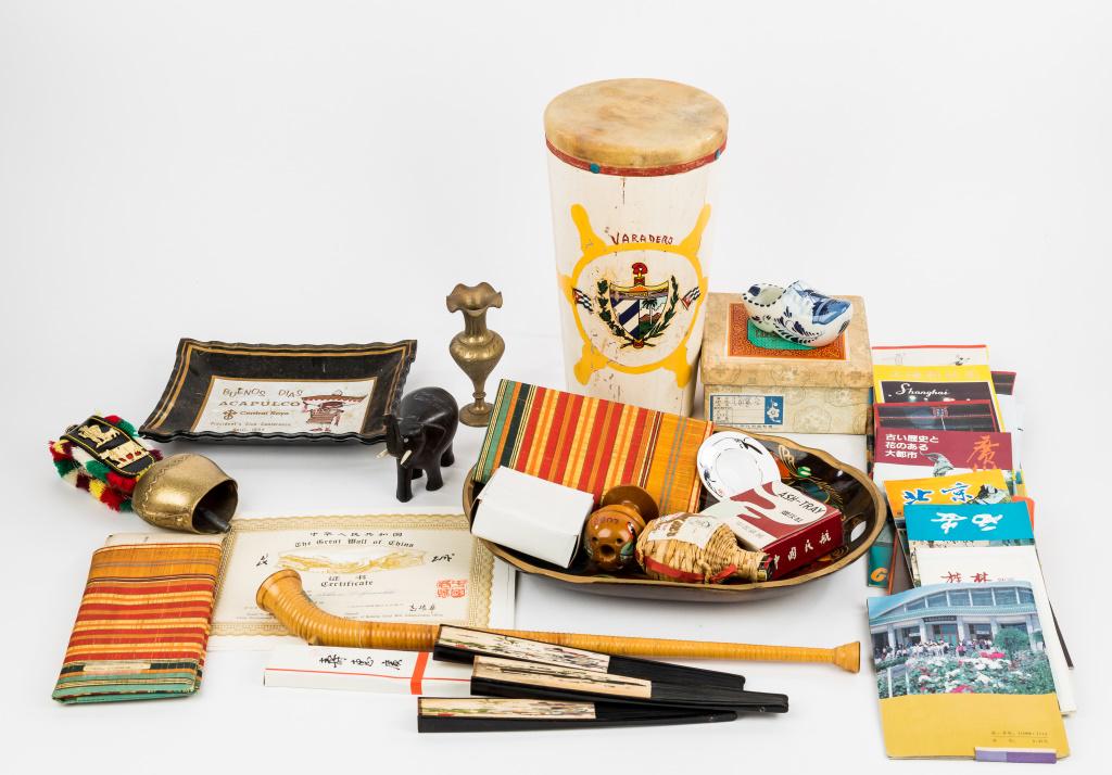 Vintage World Souvenirs: Vintage world souvenirs including Varadero wood and skin painted drum approx 11.75"H, brass India vase, mini souvenir Alpine Horn approx 18.5"L, 2 1969 Acapulco ashtrays, fans, pamphlets and more.