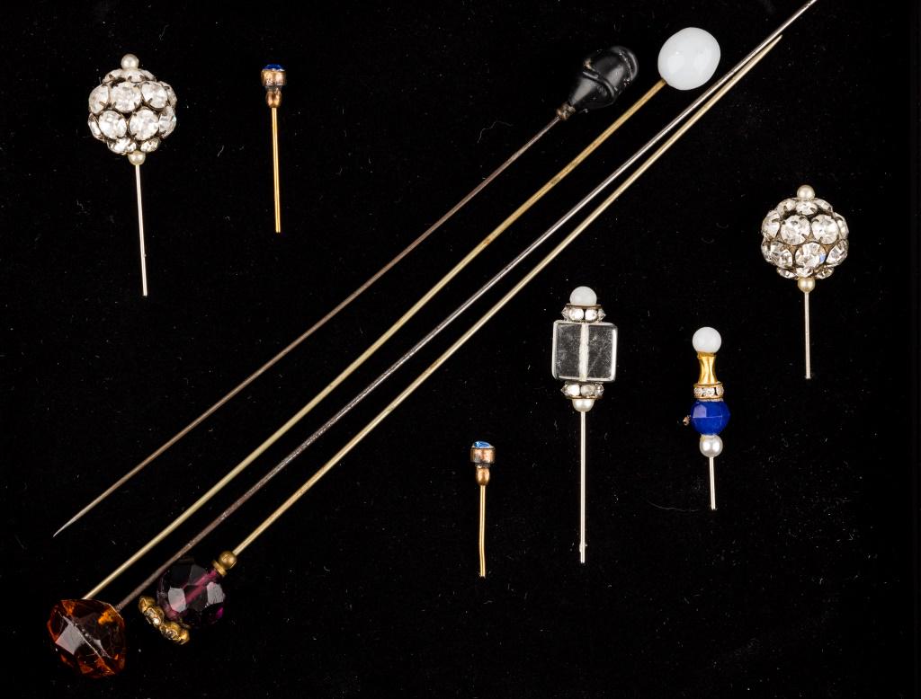 Vintage Hat Pins: 10 Hat pins featuring a 7"L purple faceted glass with pringed clear and purple rhinestone top, a 8.5"L faceted amber colored glass, a 7"L milk glass top, a 6.25"L black glass rose bud shape top, and 6