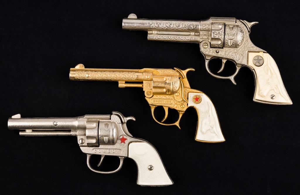 Toy Revolvers / Cap Guns (3): Texan Junior with steer on handle, Smokey Joe with red star on handle and gold tone body, and Cowboy Made In USE with red star on body. All good action. Largest approx 9".