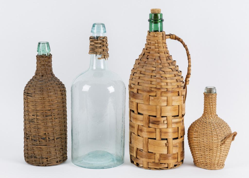 Vintage Wine Bottles: Four various sized wine bottles, wicker wrapped and woven flat oak slats. Sizes range from 8.75"H to 17"H. One bottle has only a small portion of wicker left on the neck. The largest bottle is woven w