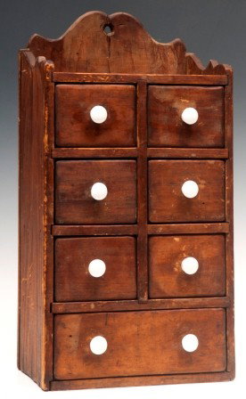 Spice Cabinet 19th/20th C: Seven drawer, softwood, hanging spice cabinet with scalloped top and porcelain knobs; 16"h x 8 1/2"w x 5 1/2"d