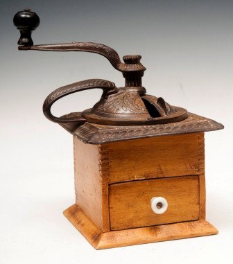 19th C Cast Iron and Wood Coffee Grinder: 19th C cast iron and wood coffee grinder with ornately cast top, slide door and wooden body and one drawer with traces of early yellow paint and a porcelain knob 10 1/2"h x 7" sq