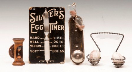 Egg Timers: Silvers Egg Timer with directions on hard board; one heavy twisted wire egg holder/boiler; one small wood egg timer and one E.Kosta metal egg timer with bell