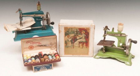Childs Sewing Machines: Two "Little Stitchers" sewing machines, one green, one blue along with empty box with sewing machine picture label for a child's sewing machine