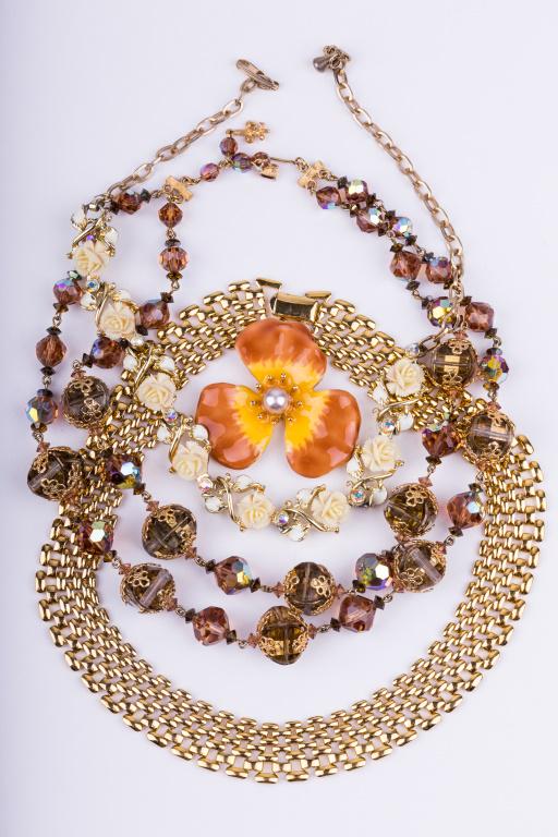 Vintage Gold Tone Necklaces & More: Three gold tone necklaces including one gold tone link necklace (approx 13" L end to end), white flower and rhinestone choker, and double strand necklace with brown beads (approx 17" L end to end) sig