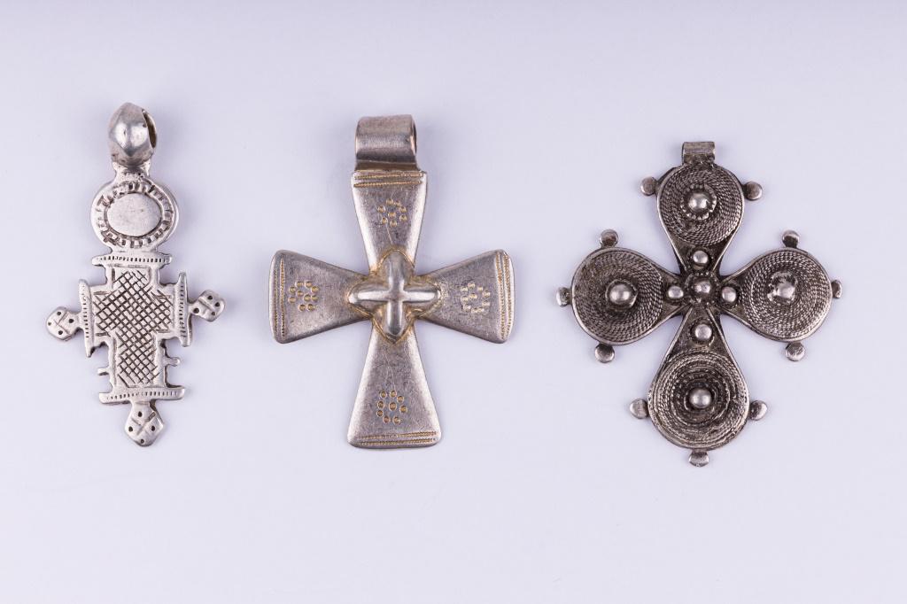 Antique Ethiopian Coin Silver Cross Pendants: Three antique Ethiopian coin silver "solve" cross pendants. Largest measures approx 2.25" l X 1.75" W. Total weight approx 1.57 ozt. One signed on reverse, illegible.
