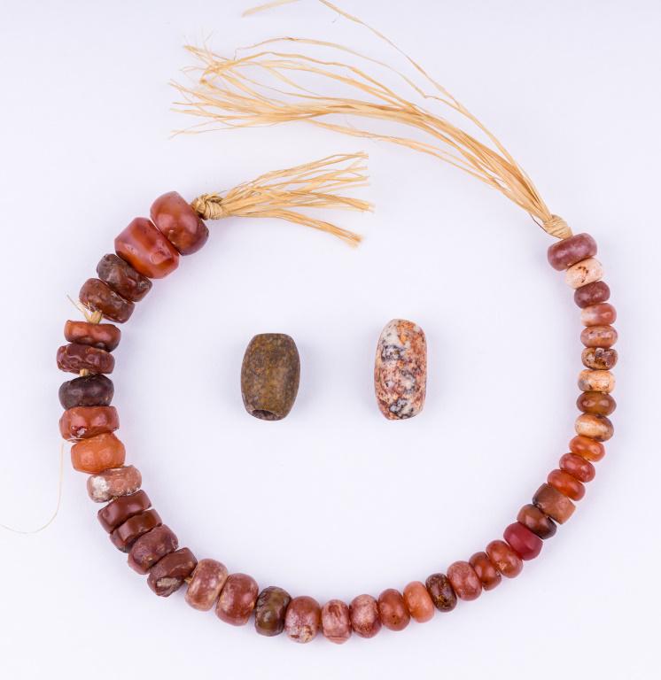 Mauritania Neolithic Carnelian & Agate Beads: String of 41 authentic graduated biconically drilled carnelian beads from Mauritania. There is also one stone and one agate bead. String of beads measures approx 9.5" L.