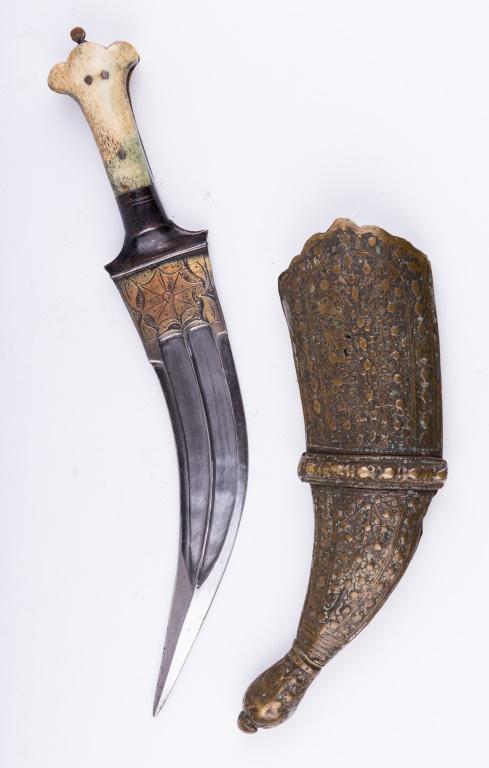 Antique Jambia karambit Dagger & Sheath: This lot is a jambia katrambit dagger that has a bone handle and blade that has engraved decoration. It measures approx 13" L. The brass sheath (which may or may not go with the dagger) has some use w