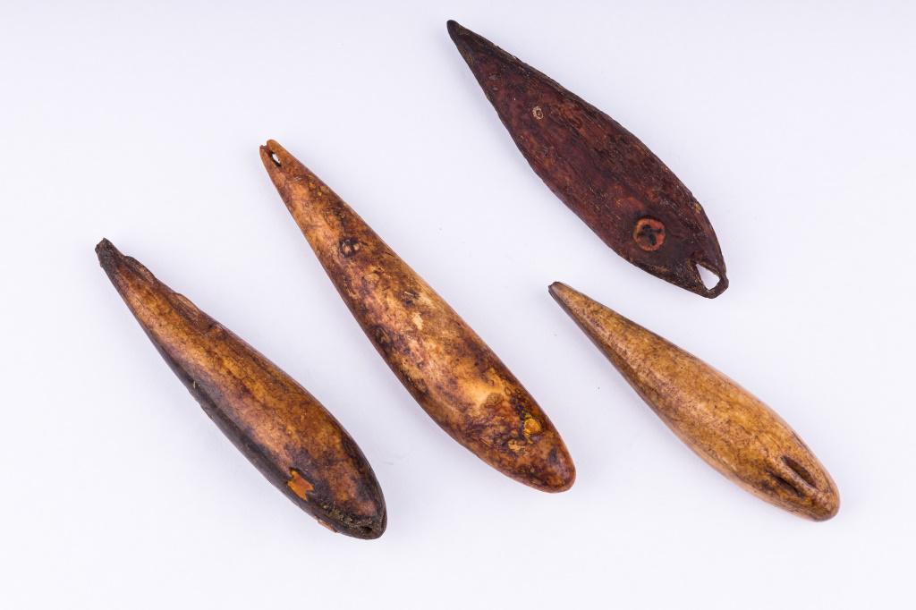 Antique Inuit Fishing Lures: Antique Inuit inupiaq (Inupiak) artifacts from Savoonga, Wales & Koyuk, Alaska. Lot consists of four carved walrus fishing lures (one carved fins). Largest measures approx 3.5" L. All three have inset