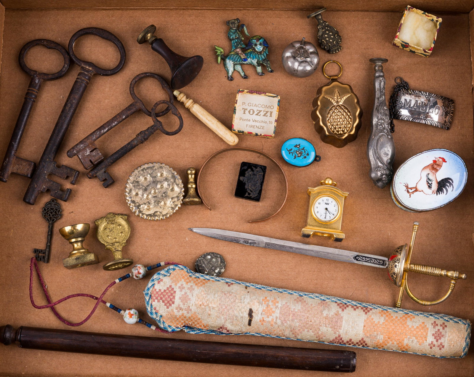 Collection of Vintage Items: Lot of vintage items includes sterling Stieff Williamsburg decanter tag, wax seal stamps, skeleton keys, woven sheath, Spanish sword / letter opener, enameled rooster trinket box, bronze cracker, Fire