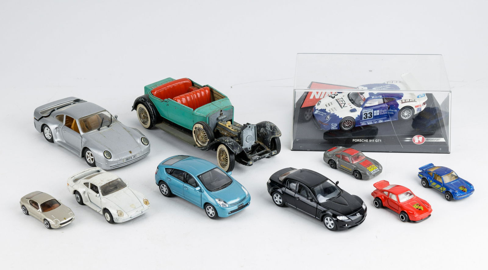 Vintage Die Cast Cars, Porsche & Others: Lot includes seven Porsche die cast cars by Revell, MC Toy, Matchbox, Majorette, Matchbox. Also includes Kinsmart Mazda and Kinsmart Toyota Prius and Hubley (for parts a restoration).