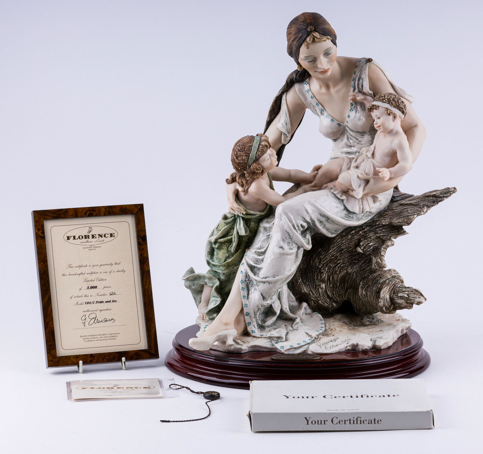 Giuseppe Armani Pride and Joy Figurine with COA: This limited edition sculpture "Pride and Joy 104C" by Giuseppe Armani Florence Italy sitting on wood base with plaque measures approx. 15" H. It is a limited edition that is numbered 126 / 3000. Fram