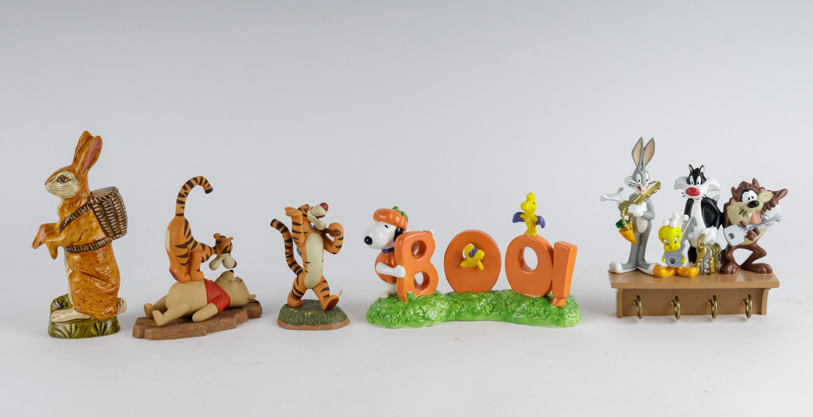 Disney & Looney Tunes Figurines (one Vaillancourt): Figurines include Snoopy Halloween pottery (approx 9" W), two Disney figurines with Tigger and Winnie, Vaillancourt Folk Art Massachusetts rabbit (approx 8.25" H) and Looney Tunes key holder. Good con