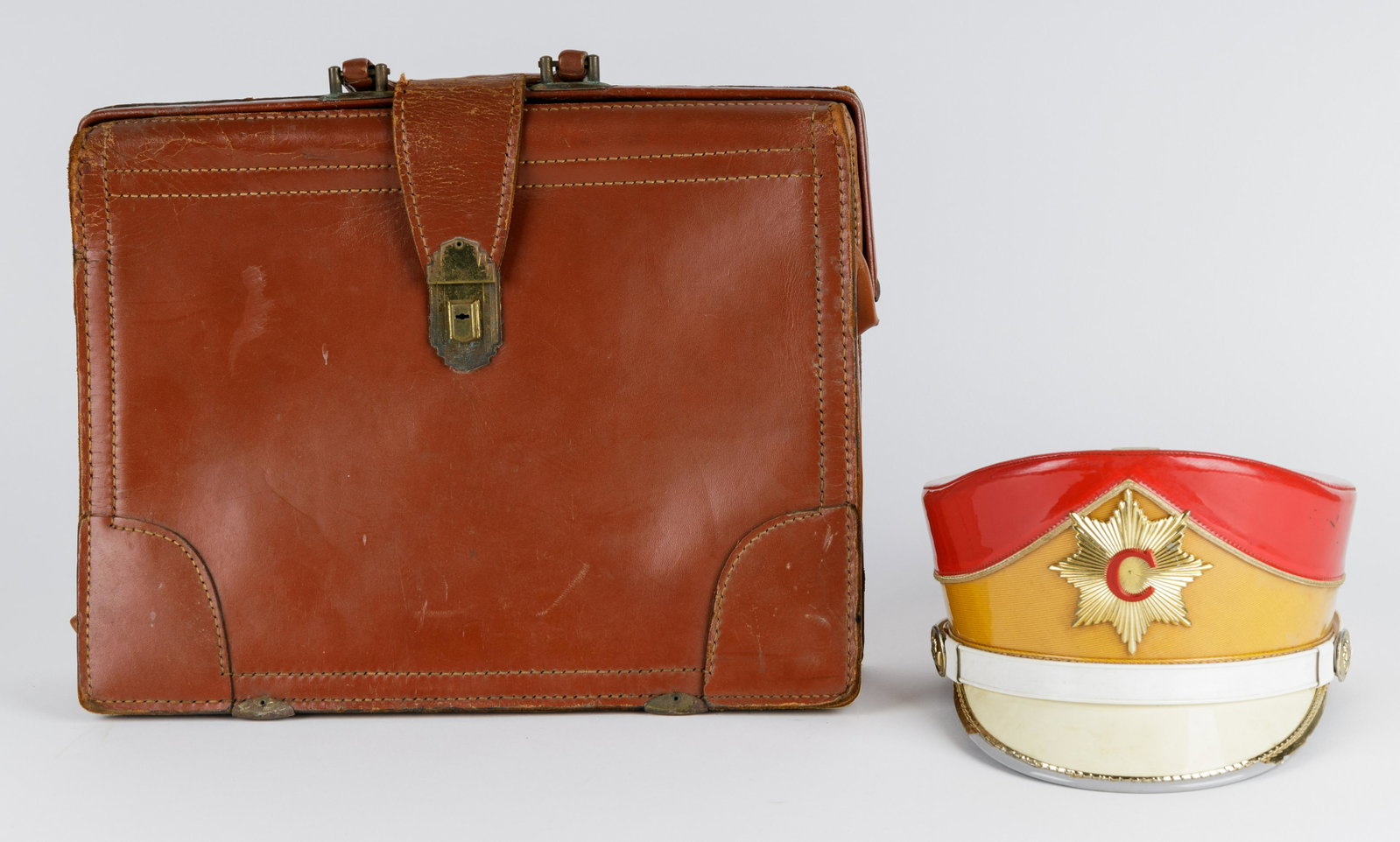 Vintage 1955 Band Cap & Leather Briefcase: Vintage band cap (suspected to be from 1955) and a similarly aged briefcase. Briefcase has a lock and key. The band hat has small dent / rip towards back of cap.