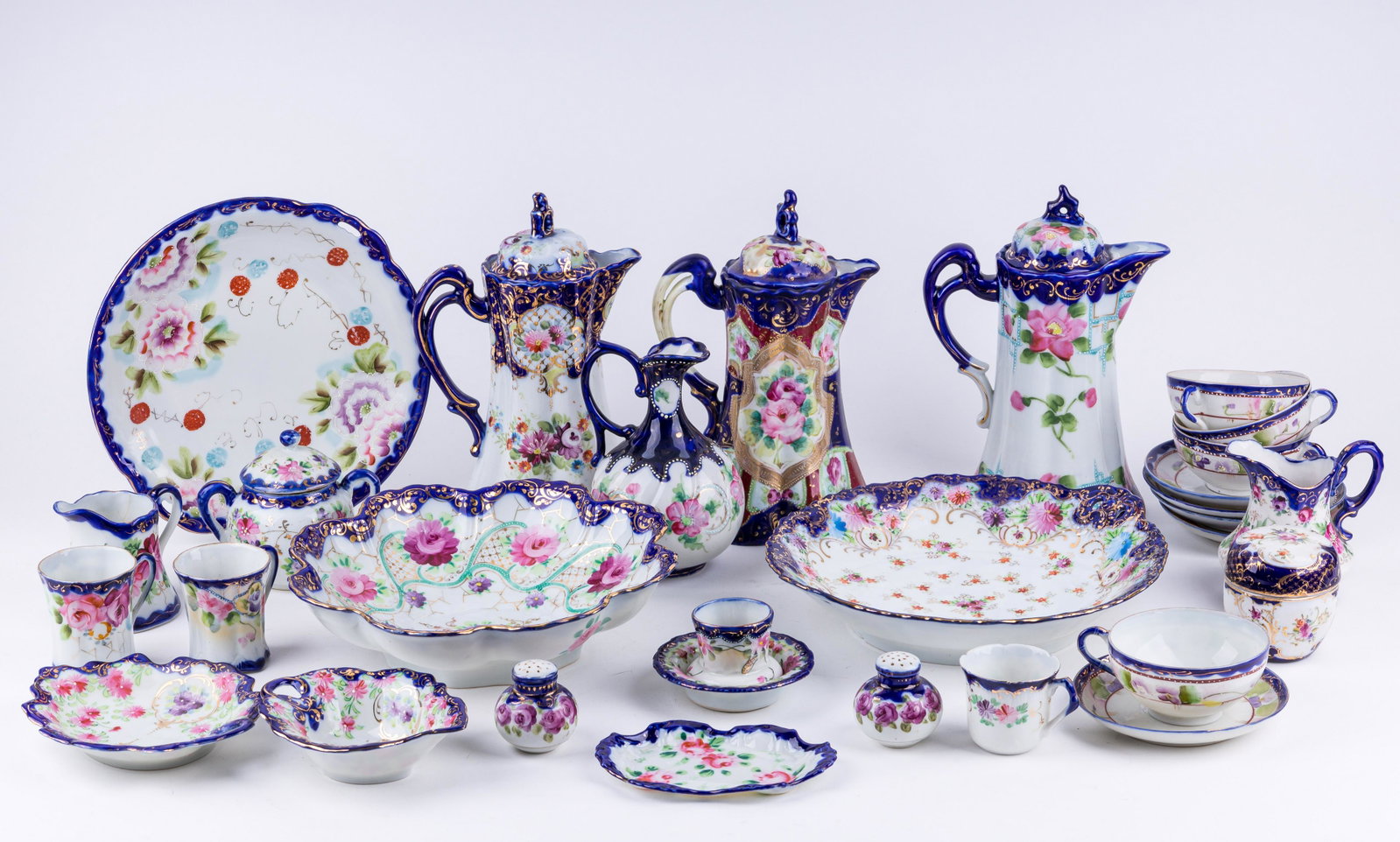 Japanese Nippon Style Porcelain China: Lot of 31 pieces of Nippon and Nippon style china including three chocolate pots, two serving bowls, one serving plate, two creamers, two sugars, three demitasse cups, six small bowls and plates, four
