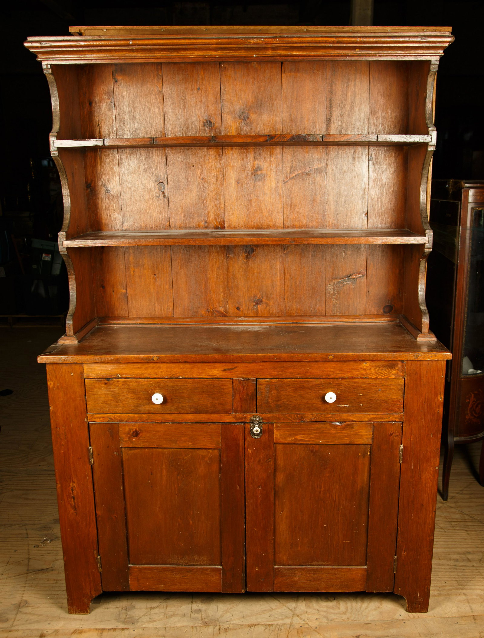 Open Shelf Pine Cupboard: Open shelf pine cupboard has porcelain knobs, two drawers, and double doors below. It measures 72" H x 49" W x 19" D. Furniture Pick-up Availability-We will have staff available at our Hay Street Loca