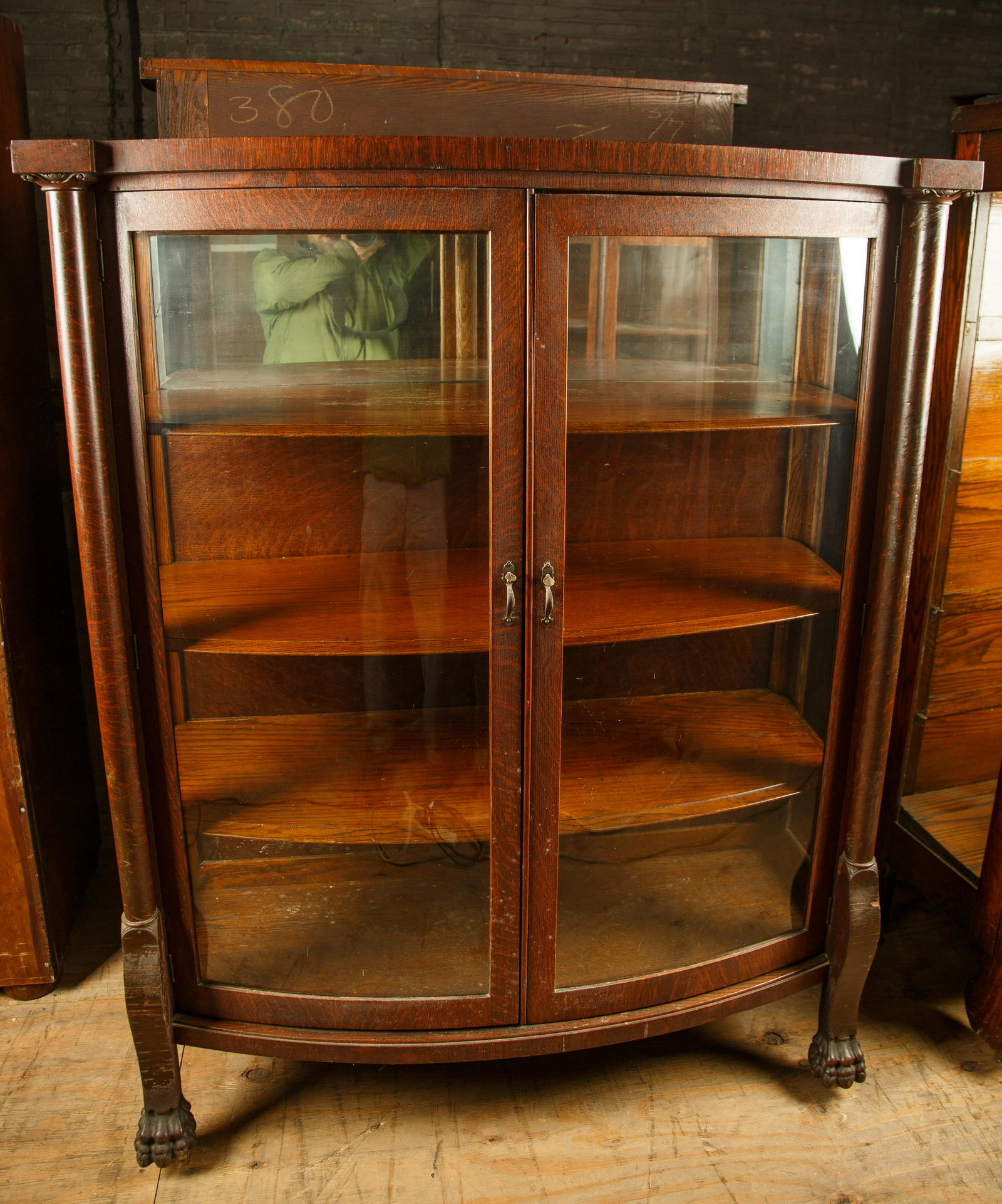 Late 19th C Swell Front Golden Oak Curio Cabinet: Curio cabinet with three shelves measures 60" H x 48" W x 17 1/2" D. Furniture Pick-up Availability-We will have staff available at our Hay Street Location on Thursday the 20th and Friday the 21st or 