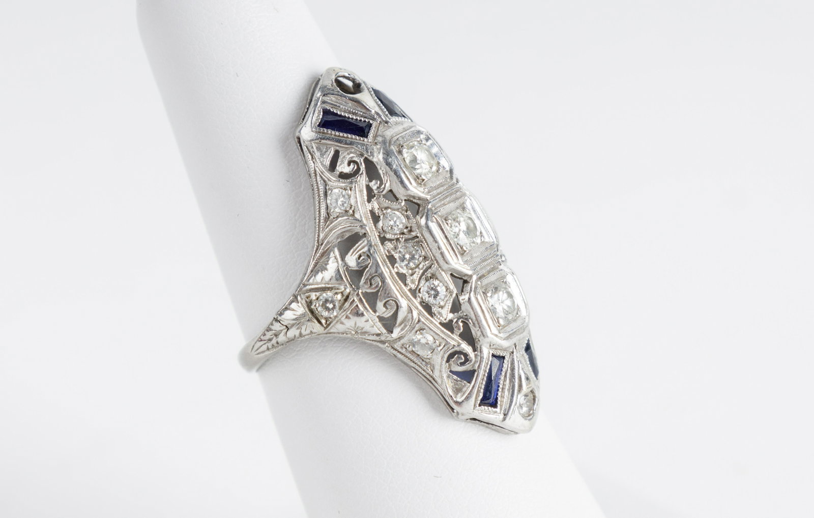Antique Platinum Diamond Art Deco Ring: Platinum Art Deco ring with 3 round cut diamonds set in square mountings bead set in square mounting with mil grain and engraving, four saw tooth bezel set French cut synthetic sapphires. Total weight