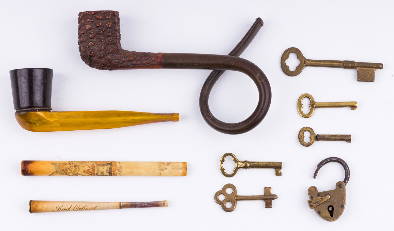 Antique and Vintage Keys, Pipes & More: Two pipes including one has a real amber handle and a curled pipe marked Postillo Italy. Two cigarette holders including one that's made of bone with Asian style engraved design and a Lord Calvert cig