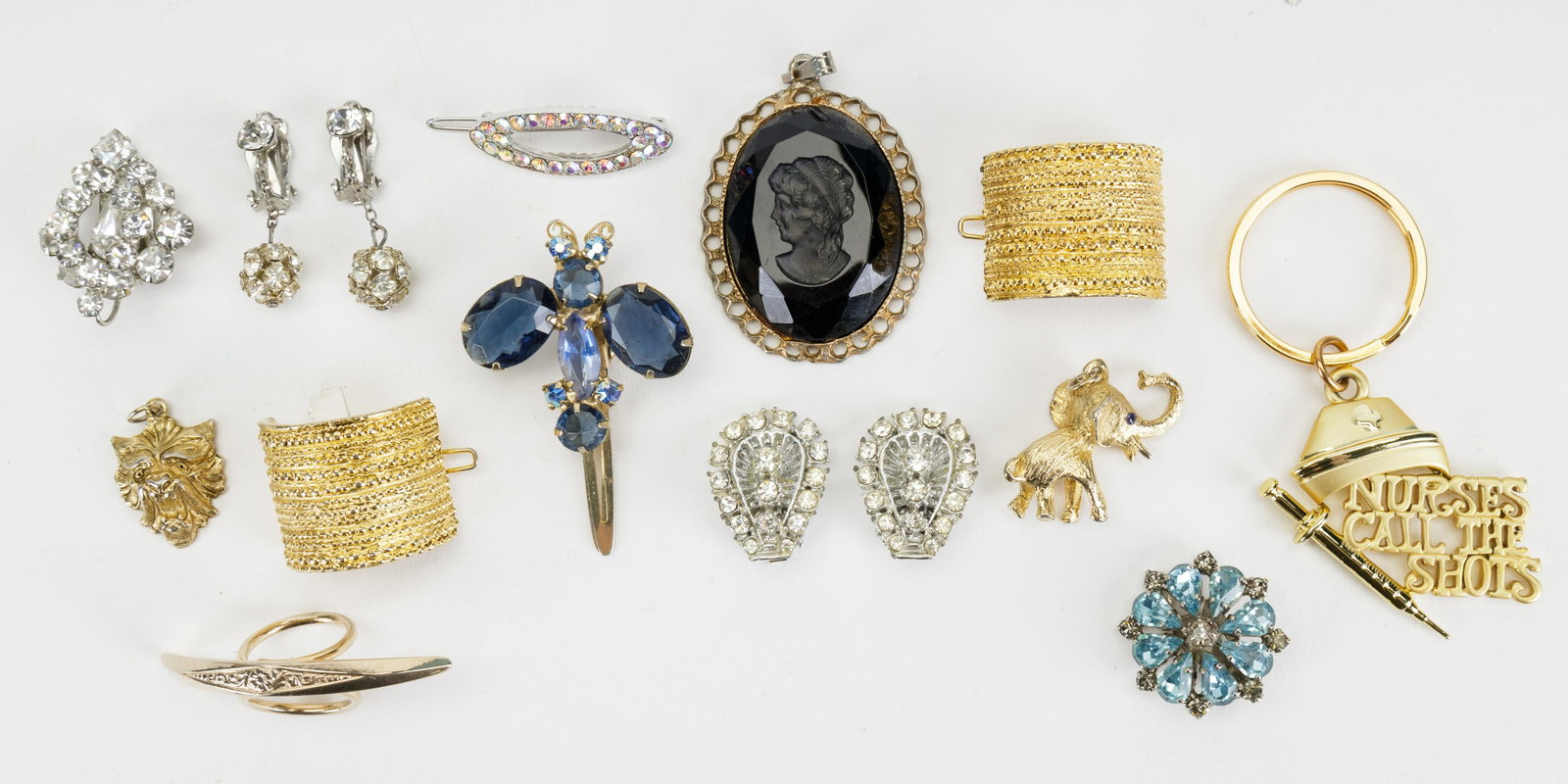 Costume Jewelry / Pendants: Lot has 12 items featuring an elephant pendant, a lion pendant, a single pronged rhinestone earring, a black faceted glass cameo and more.