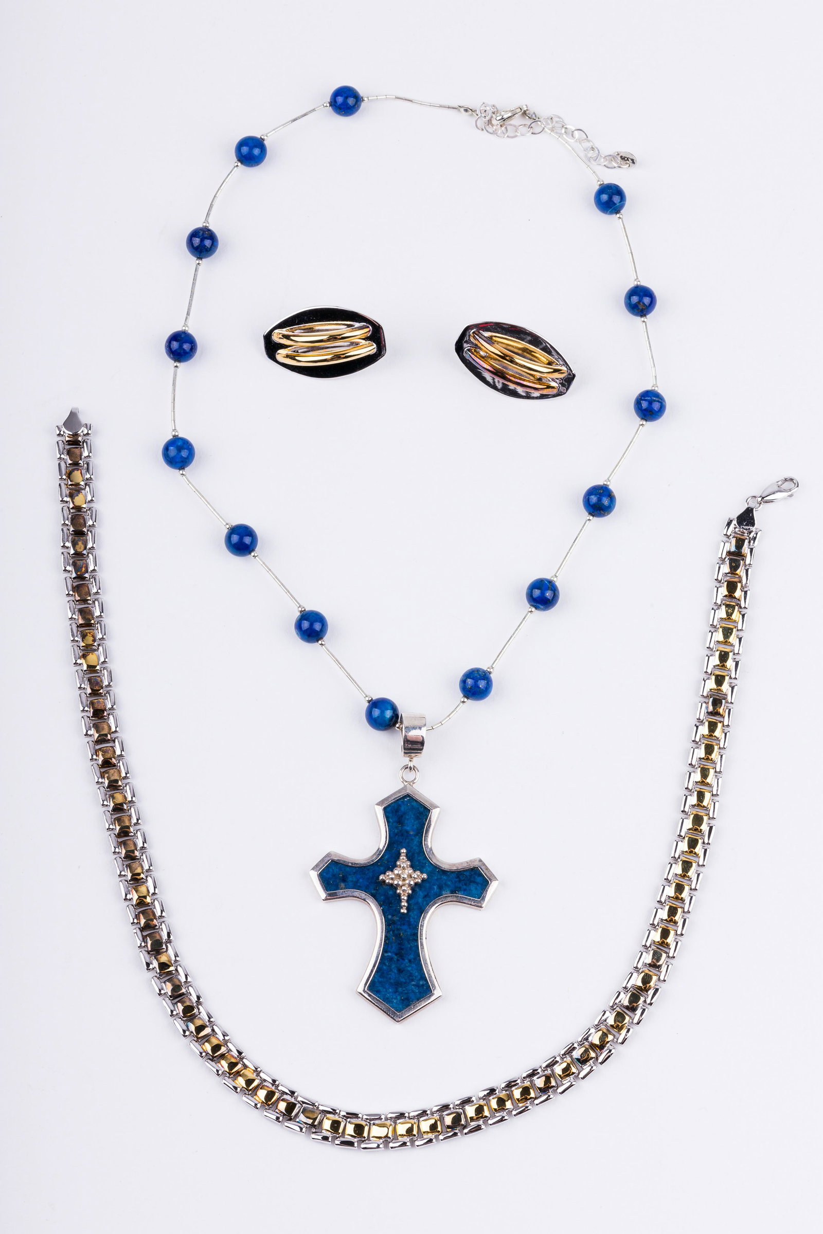Sterling Silver Necklaces & Earrings: Lot of two necklaces and one pair of earrings including religious cross necklace with lapis stones. There are also a pair of sterling silver and gold wash earrings and a sterling and gold wash necklac