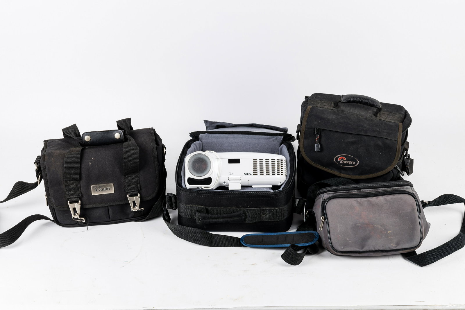 NEC Digital Projector & Camera Bags: NEC digital projector and three camera bags including Lowepro, Canon and an unmarked. Projector turns on but has not been tested. Bags are in used condition as found.