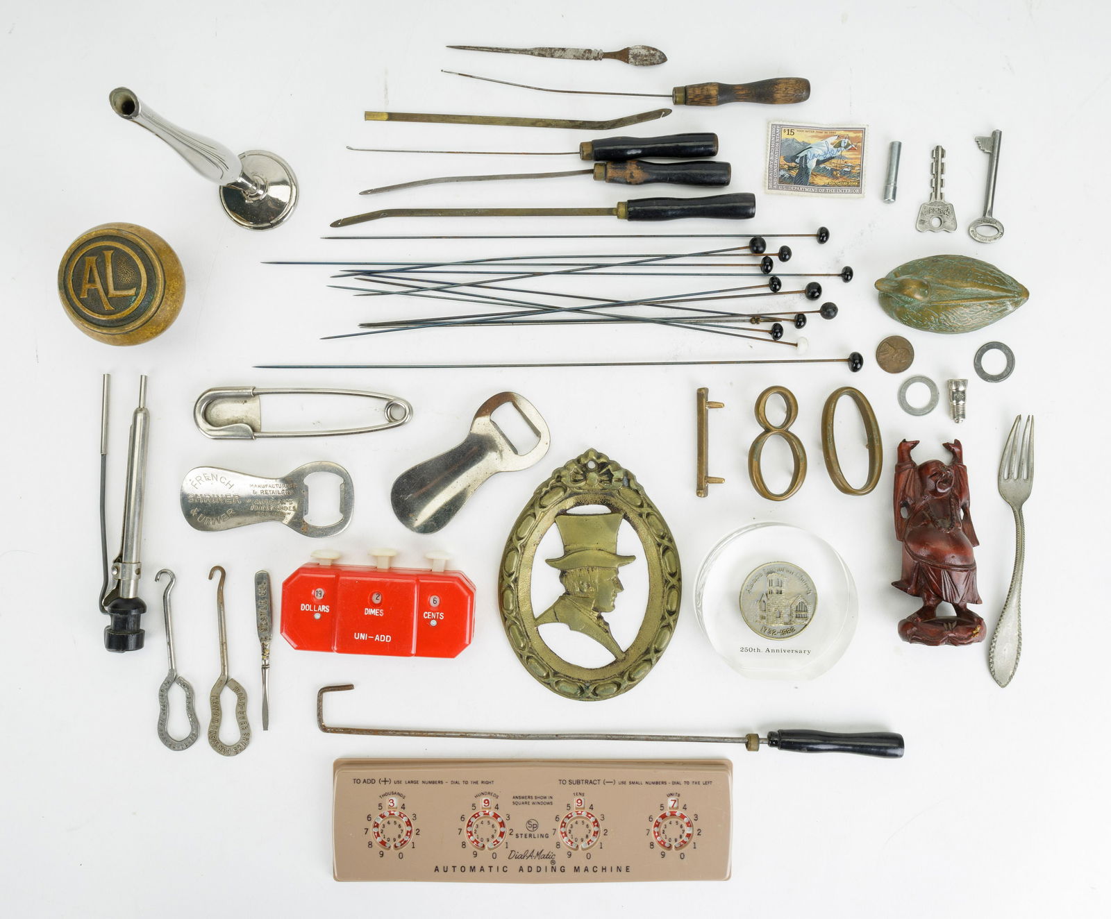 Dresser Items: Autographed U.S. Dept of the Interior duck stamp, hat pins, bottle openers, money counting clicker, Buddha figurine, advertising screwdriver for C. Nestle Company used for Bakelite handles, mini curli