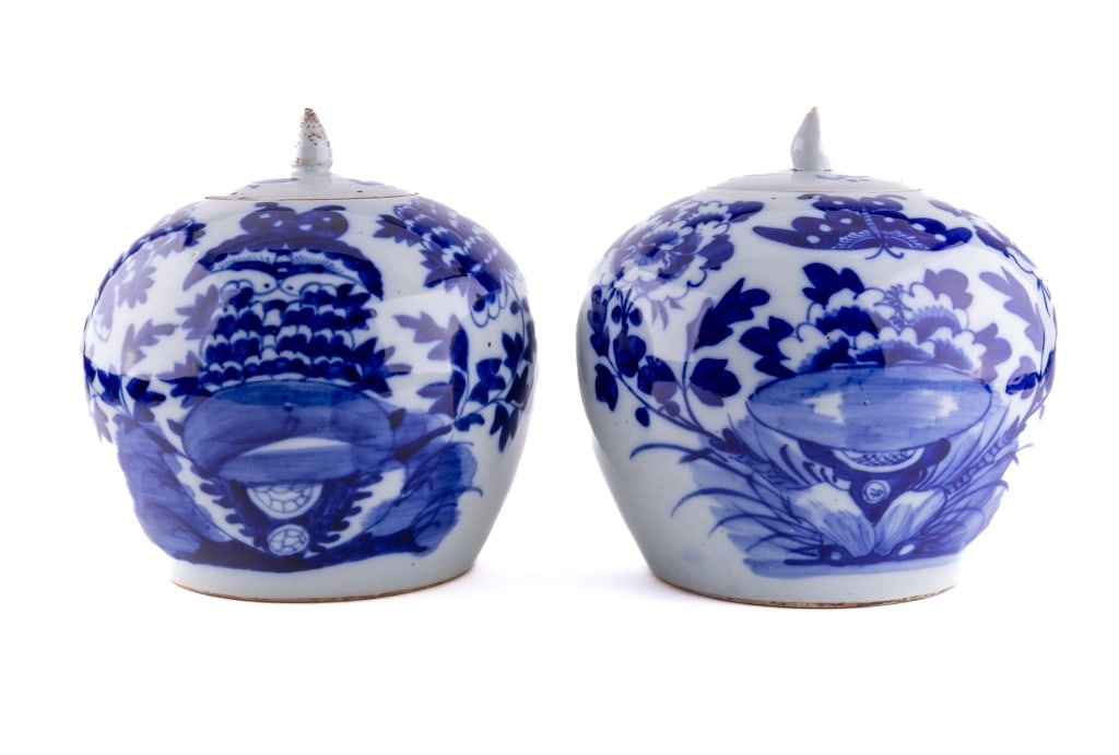 Pair of Blue & White Lidded Chinese Ginger Jars: A pair of lidded blue and white Chinese ginger jars measuring 9" tall to top of finnial. Likely 19th Century, showing insect and floral art.