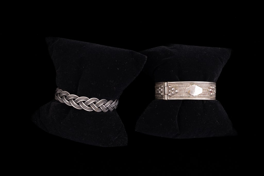 Unmarked Silver Bracelets (2): One is hinged with safety chain. The other has a damage. Neither is marked but believed to be sterling from India. Inner dimension approx 2.5"