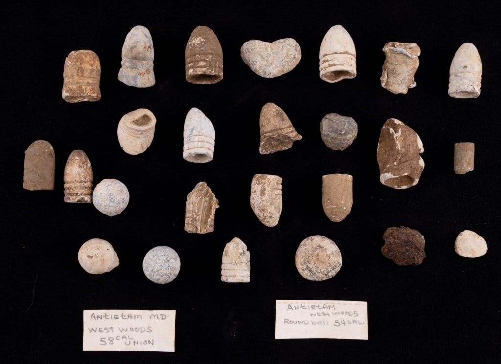 Civil War Bullets & Mini Balls: Civil War bullets and mini balls. Two tags within the group say: "Antietam MD, West Woods, 58 Cal Union" and "Antietam, West Woods, round ball, 54 cal". See photos