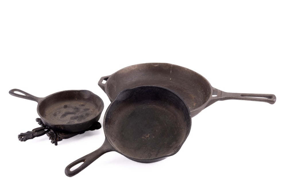 Cast Iron Skillets & Trivets: Cast Iron Skillets & Trivets including Griswold 11.5", Wagner Sidney 8" #1055C, Wagner Sidney 6" #1053B, 1950 J.Z.H. Pennsylvania Dutch trivet.