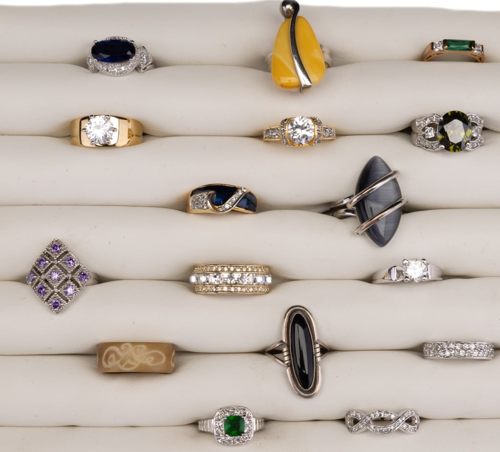 16 Cocktail Rings: 16 cocktail rings including a sterling and onyx ring (approx 6.5). There are two bands with diamond chips (band - size 5 and infinite - size 8). Stones test for quartz, amethyst, peridot and more.