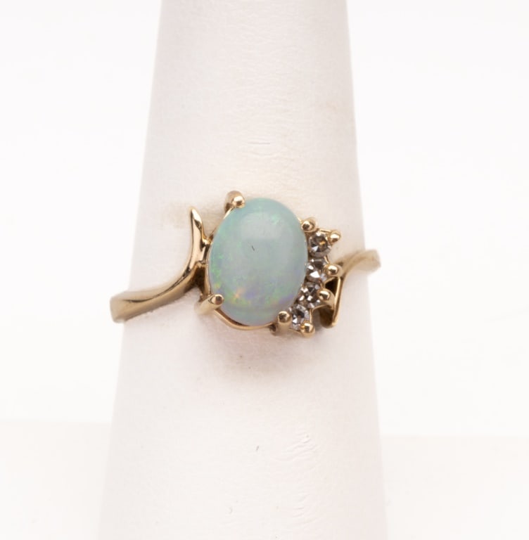14K Gold Opal and Diamond Ring: A 14K gold ladies size 8 ring with center opal and 3 accent diamonds on one side. Approx 2.10 DWT