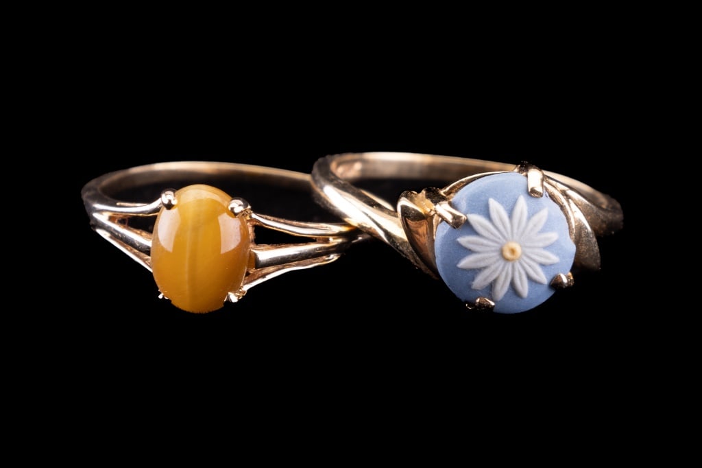 Two Yellow Gold Rings: Two yellow gold ladies rings. A 14K gold size 7 ring with Wedgwood daisy (approx 2.7g). The second ring is unmarked with possibly a light tiger eye stone (approx 1.7g), size 7 and total weight approx 