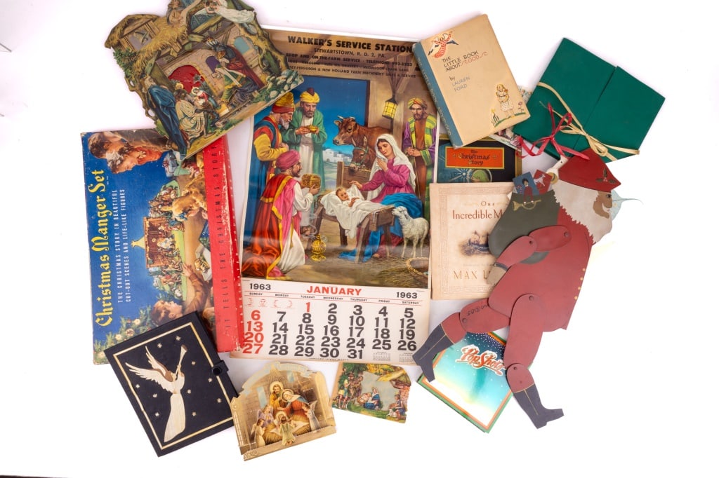 Christmas Nativity Books, Ephemera & Tin Santa: Collection of 16 pieces, featuring eight-piece paper die cut Nativity set, three books, two 3D woodcut pieces, one 1963 calendar, one boxed cut-out set, and one ten articulated Santa (19" high).