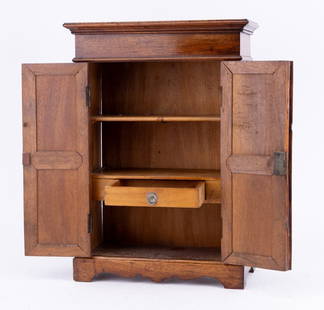 19th C Miniature French Armoire: Exceptionally made c 1850 miniature armoire approx 16.5" H x 11.75" W at top x 5.25" D. Made of fruitwood, two panelled doors, interior drawer, scalloped apron and includes key to lock doors. Also inc