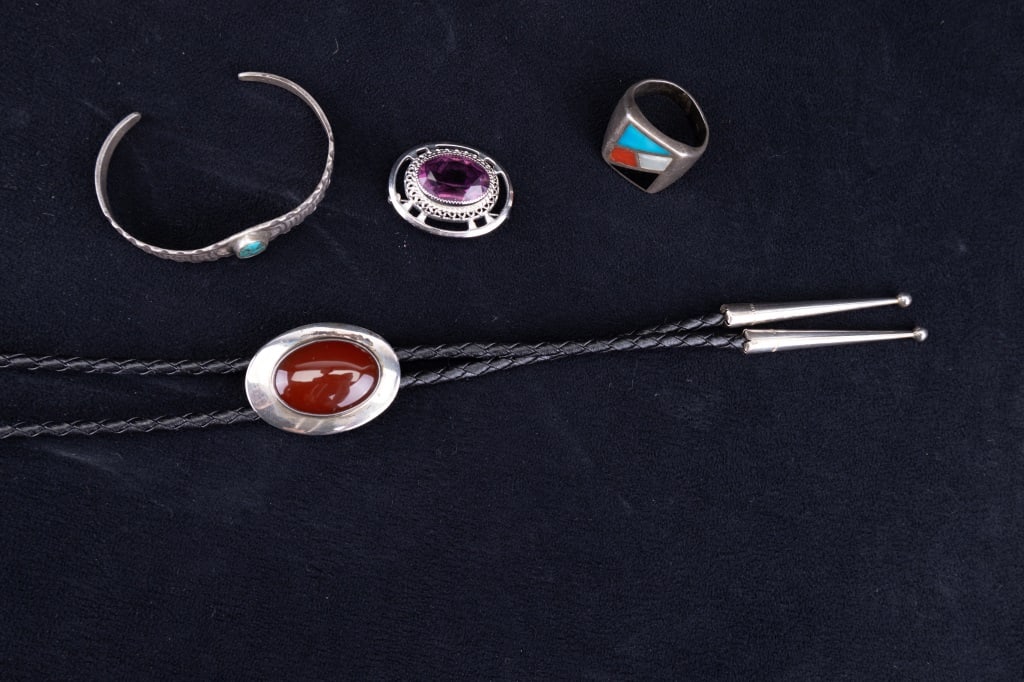 Don Chavez NA Bolo & Other Sterling Jewelry: Don Chavez bolo with sterling silver carnelian central accent on black leather cord, sterling silver ring (size 10.5) with turquoise, coral, mother of pearl and onyx. There is also a sterling silver D