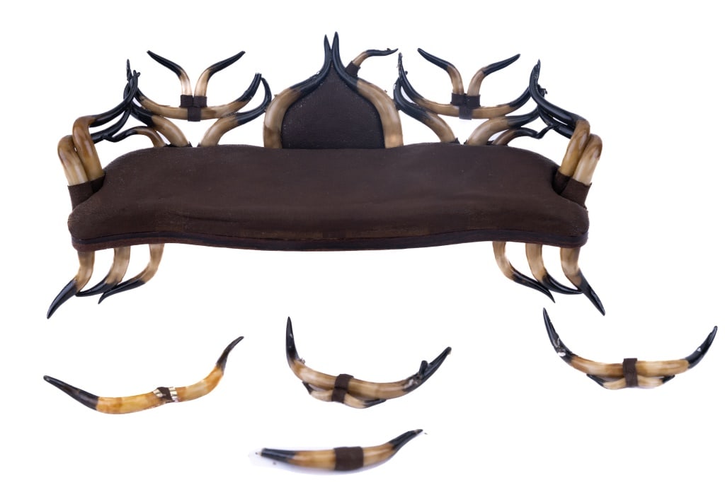 Susanne Russo Antler Sofa Miniature: Brown suede antler horn sofa signed by Susanne Russo. Approximately 2 3/4" tall x 6 1/2" long x 2 1/2" wide. Some horns have detached (included). Similar piece for sale on maker's website for $1,275.0