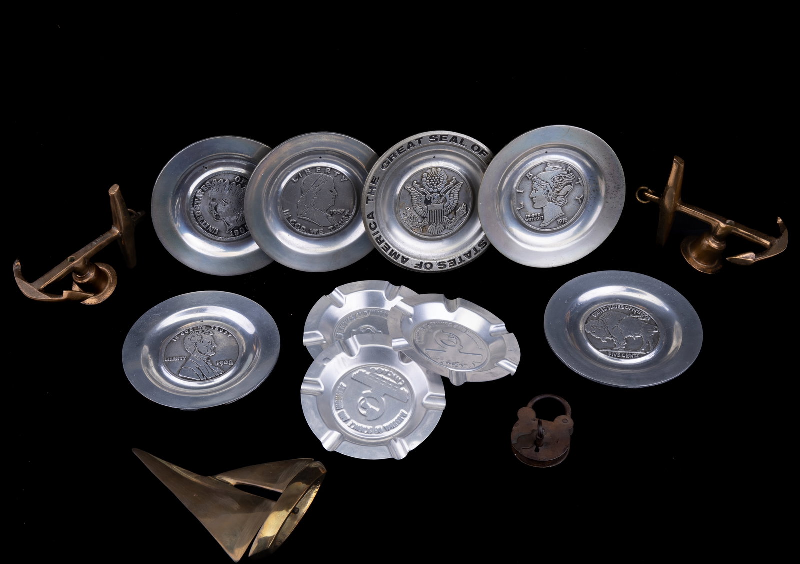 Pewter Plates & Maritime Decoratives: Pair of leaning anchor brass candlestick holders, solid brass sailboat, 6 pewter United States commemorative plates, 3 Museum of Science and Industry Chicago ash trays and a lock and key. All commemor