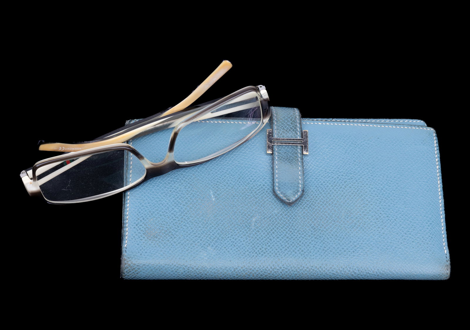 Hermes Paris Luxury Wallet & Gucci Glasses: Iconic Hermes "H" clutch wallet in sky blue leather stamped with in silver with "Hermes" and "Paris." Made in France. Overall excellent condition. Slight wear. Iconic Gucci horn design glasses with ou