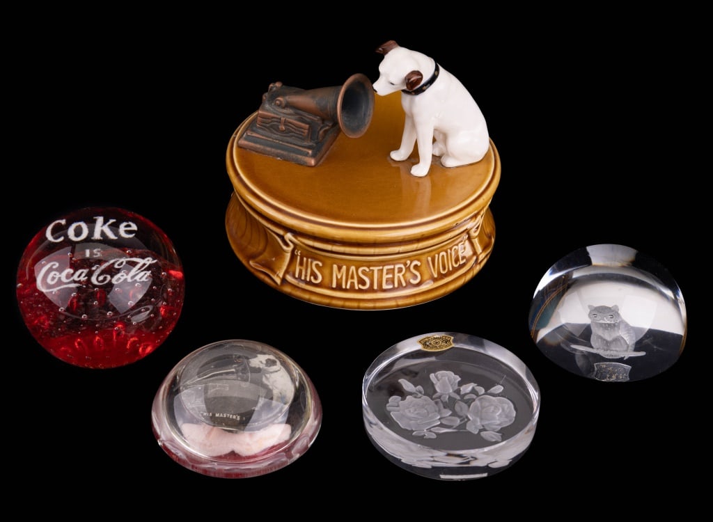Glass Paperweights & More: 4 glass paperweights. Names include VSL and CocaCola. Some tearing on underside of one. Also includes rotating musical carousel reading "His Master's Voice." Approx. 6" H x 5 1/2" Dia.