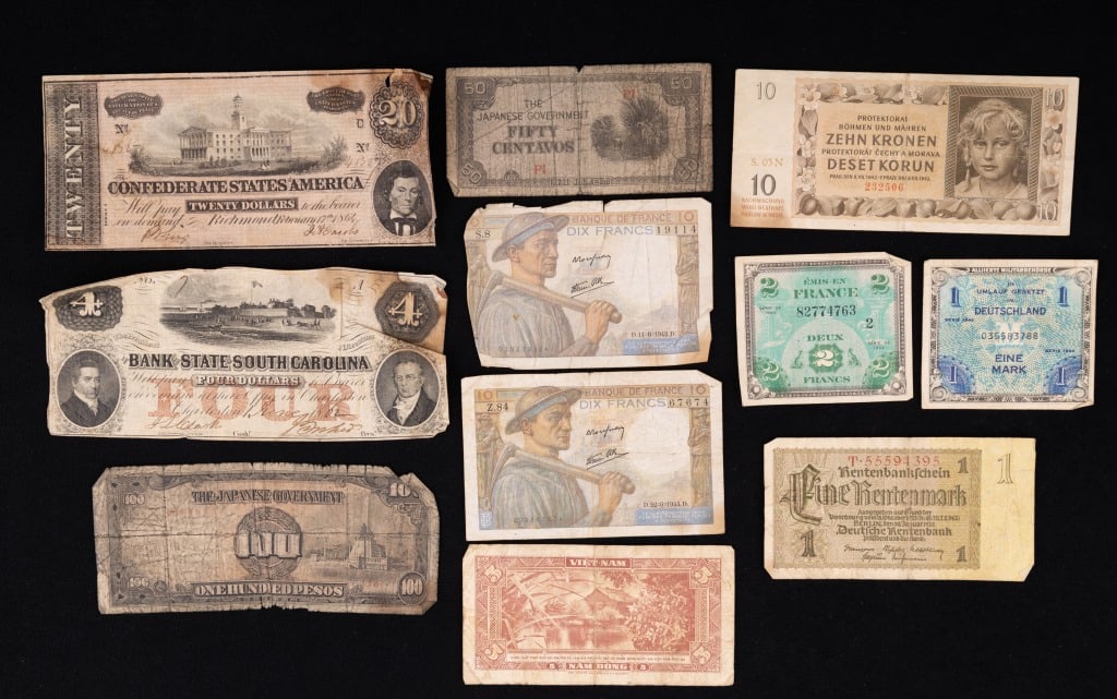 Confederate & International Currency: 11 pieces of currency including confederate and foreign. There is a $20 confederate bill, $4 Bank of South Carolina, (2) Japanese, (2) France, Vietnam, Germany and another. All in used condition.