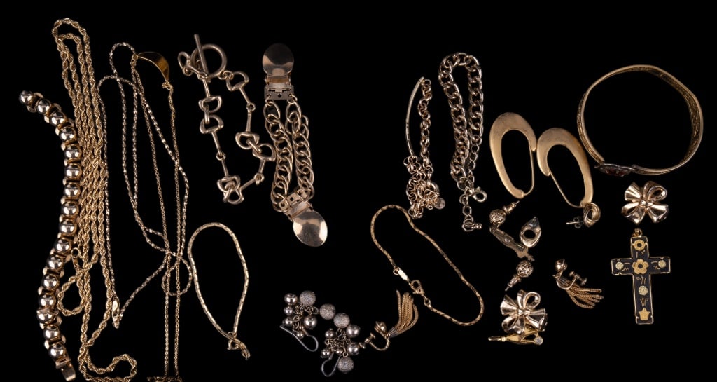 Gold Tone Necklaces, Earrings & Bracelets: Lot of gold tone jewelry including necklaces, scarf clip, earrings, bracelets, and more. There are a pair of Trifari bow earrings, GF dangle screwback earrings, Monet bracelet, damascene cross.
