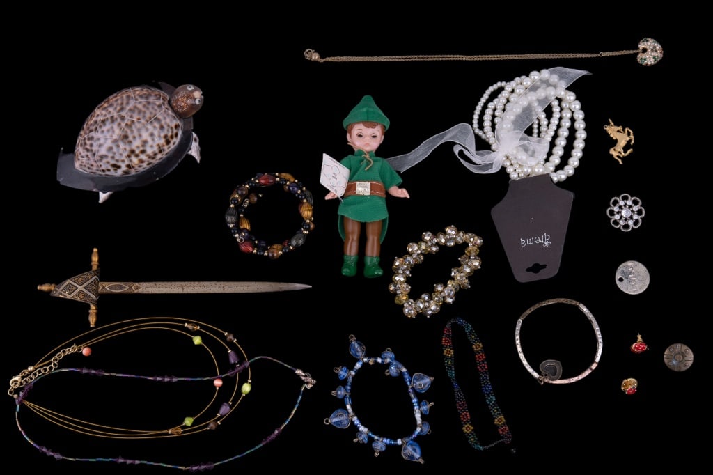 Vintage Desk Items and Costume Jewelry: Vintage desk items and costume jewelry including a 5" shell turtle, a Madame Alexander Peter Pan doll, vintage sword letter opener, and misc costume jewelry.